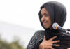 Ilhan Omar speaking at a microphone during an event