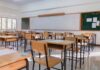 Fake Superintendent: Guns, Lies, Deportation An empty classroom with wooden desks and a chalkboard