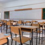 Fake Superintendent: Guns, Lies, Deportation An empty classroom with wooden desks and a chalkboard