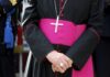 A religious figure in ceremonial attire with a cross necklace