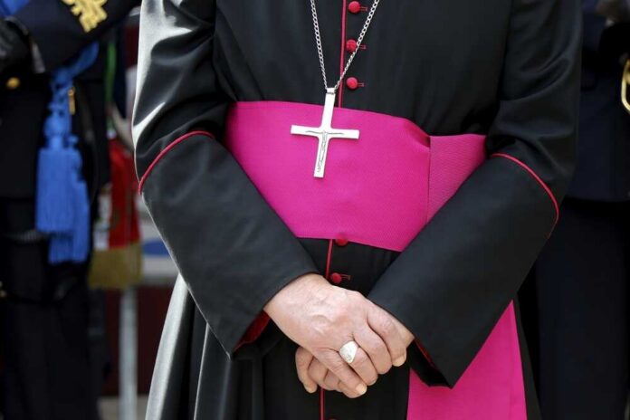 A religious figure in ceremonial attire with a cross necklace