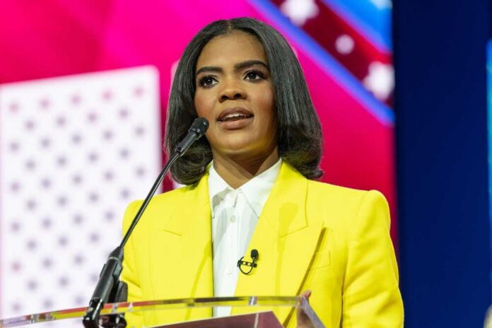 A woman in a yellow blazer speaking at a podium with a microphone