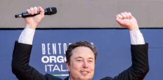 Person with a microphone raising hands in celebration