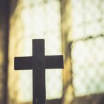 Churches in Crisis: Abortion Debate Roils Silhouette of a wooden cross against a softly lit background