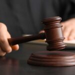DOJ Faces Court Over High-Profile Prosecutor Firing A judge's hand holding a gavel above a wooden block