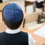 BIZARRE Discovery: Iranians Running Israeli Daycare Illegally Back view of a Jewish boy wearing a kippah in a classroom setting