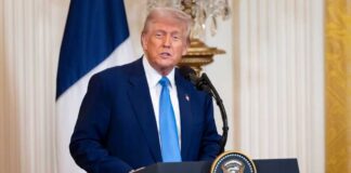 Donald Trump delivering a speech at a podium in the White House