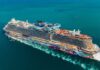 A large, colorful cruise ship sailing on clear blue waters