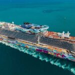 Floating Amusement Parks: The New Vacation Trend A large, colorful cruise ship sailing on clear blue waters