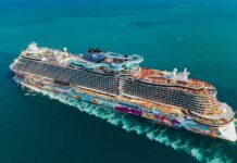 A large, colorful cruise ship sailing on clear blue waters