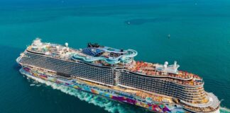 A large, colorful cruise ship sailing on clear blue waters
