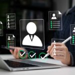 Resume Robots: Are Humans Being Shut Out? Recruiter reviewing digital resumes on laptop and tablet