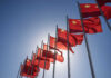 Hidden Truth: Did Trump Bend on Taiwan? Multiple Chinese flags waving against a clear blue sky