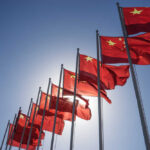 Hidden Truth: Did Trump Bend on Taiwan? Multiple Chinese flags waving against a clear blue sky