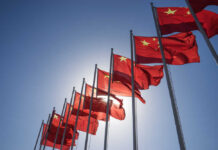 Hidden Truth: Did Trump Bend on Taiwan? Multiple Chinese flags waving against a clear blue sky