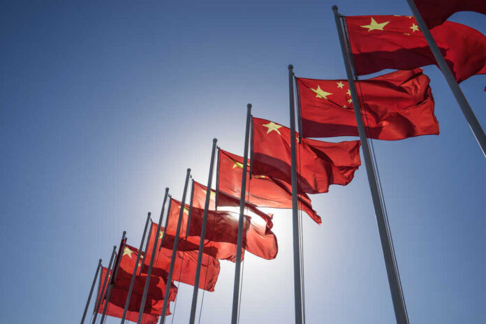 China,Flag Multiple Chinese flags waving against a clear blue sky