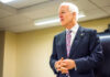 A man in a suit delivering a speech in a conference room