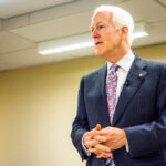 A man in a suit delivering a speech in a conference room