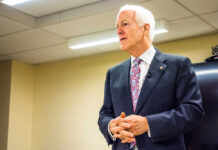 A man in a suit delivering a speech in a conference room