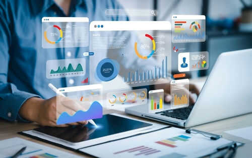 2285412737 Person analyzing data on tablet and laptop.