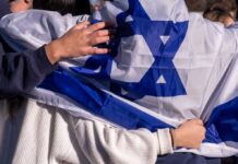 Israel Integration Plan Triggers BACKLASH People holding an Israeli flag together, showcasing unity and cultural pride