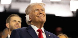 Smiling older man in a suit with a red tie at an indoor event