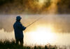 Hunting, Fishing Redefined — As Felonies A fisherman standing by a misty lake at sunrise, holding a fishing rod