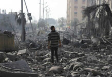 Human Shields Or Horror Story? Person walking through rubblestrewn street in daylight