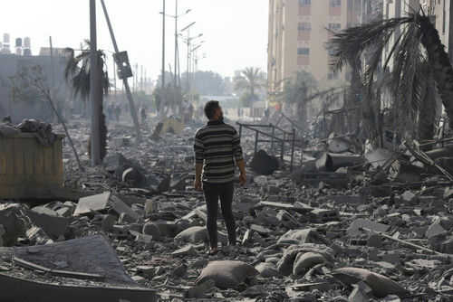 gaza2402350653 Person walking through rubblestrewn street in daylight