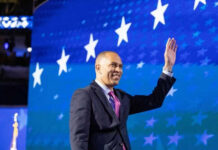Person waving in front of a starry blue background
