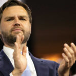 Man in suit clapping at an event