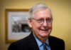 McConnell Slams Brakes — No Backdoor Bill Smiling man in suit with round glasses indoors.