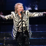 Man performing on stage wearing zebra-print outfit