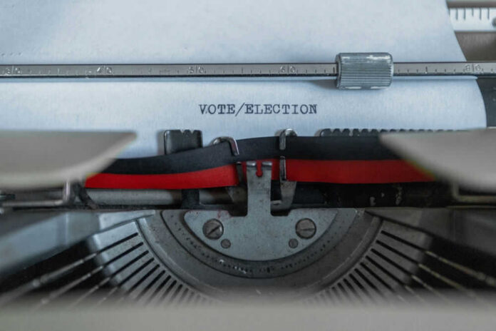 Typewriter typing the words VOTE/ELECTION on a sheet of paper