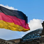 UN Power Play Leaves Germany on the Sidelines German flag waving against a blue sky near a historic building