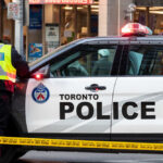 Consulate Gunfire Trail — Toronto Cop Killed Police officers in high-visibility jackets with radios.