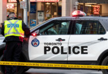 Consulate Gunfire Trail — Toronto Cop Killed Police officers in high-visibility jackets with radios.