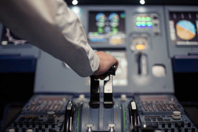 Electronic,Panel.,Pilot,In,The,Aircraft,With,Dashboard.,Pilot,Looks Pilot's hand operating the throttle in an aircraft cockpit