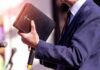 MAGA Pastor Implodes ā Texts Trigger Exit A person in formal attire holding a Bible while speaking