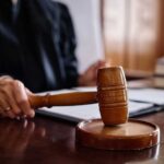 Shocking Deal Lets Child Abuser Walk A judge's hand holding a gavel in a courtroom setting