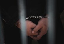 Reckless Run: Kid Abandoned Mid-Chase Close-up of handcuffed hands behind bars
