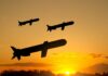 World’s Gun Store? Silicon Valley’s Bold Gambit Silhouettes of missiles flying against a sunset backdrop