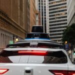 Rear view of a Waymo autonomous vehicle on a city street
