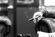Hands passing a lit joint between people