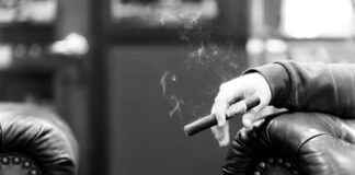 Hands passing a lit joint between people