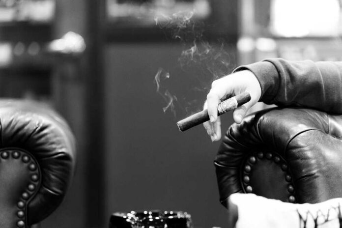 Hands passing a lit joint between people