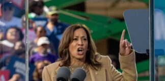 A woman passionately delivering a speech at an outdoor rally