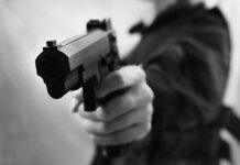 Love Triangle Turns Deadly On-Base Close-up of a person holding a handgun in a threatening manner