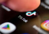 TV Spins TikTok Tragedy Into Panic Finger tapping TikTok app on a smartphone screen