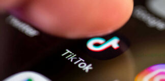 Finger tapping TikTok app on a smartphone screen